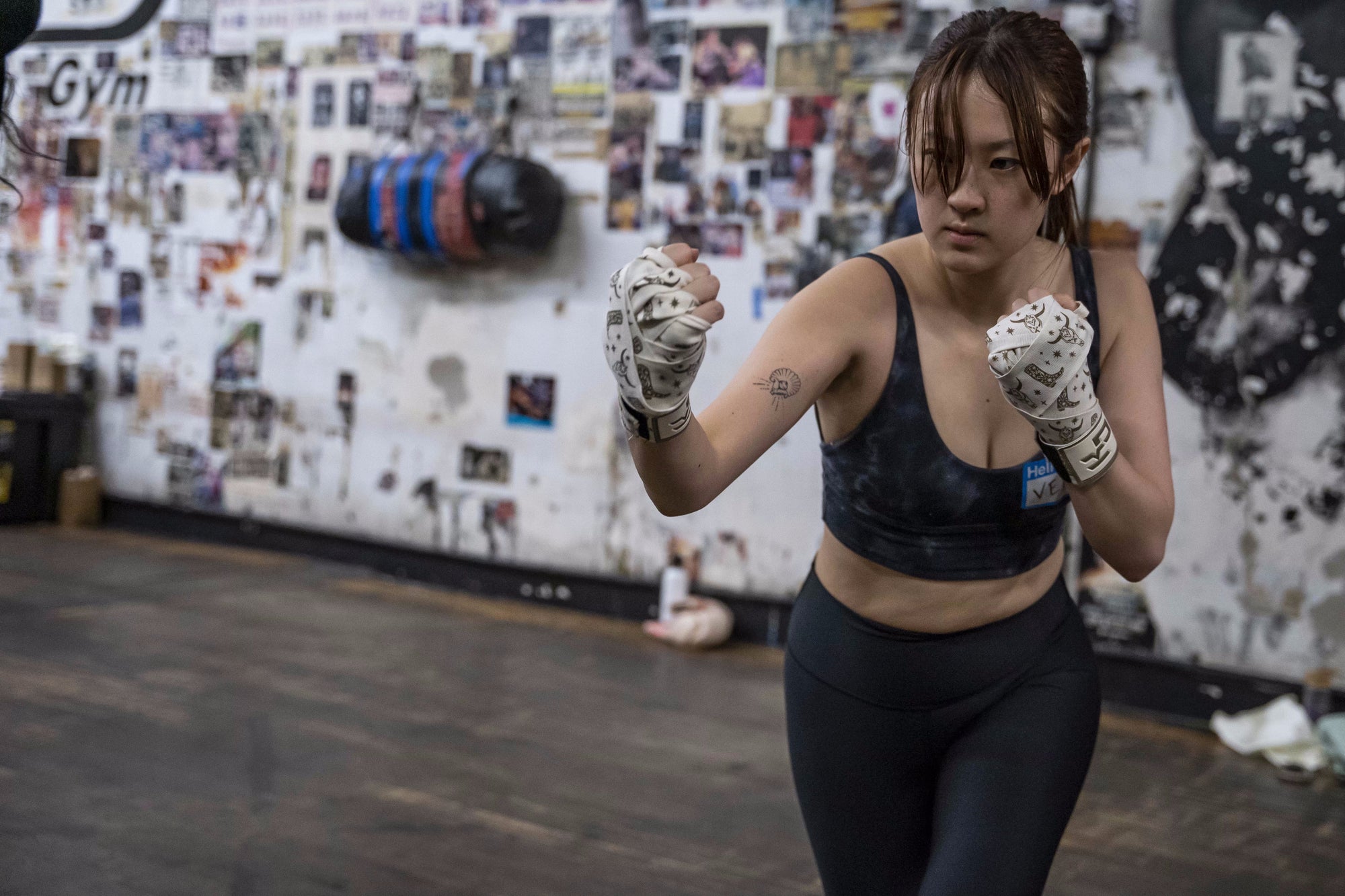 Woman wearing KO Studio boxing gloves and hand wraps, ready to train